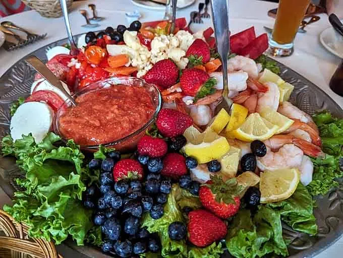 An antipasto platter with shrimp, berries and vegetables